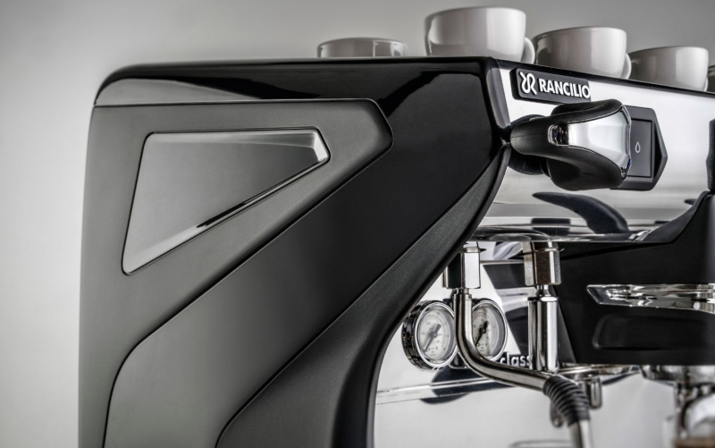 This image is a closeup front-side view of the Rancilio Classe 7 espresso machine steam wand, steam c-lever, gauge and side panel. 